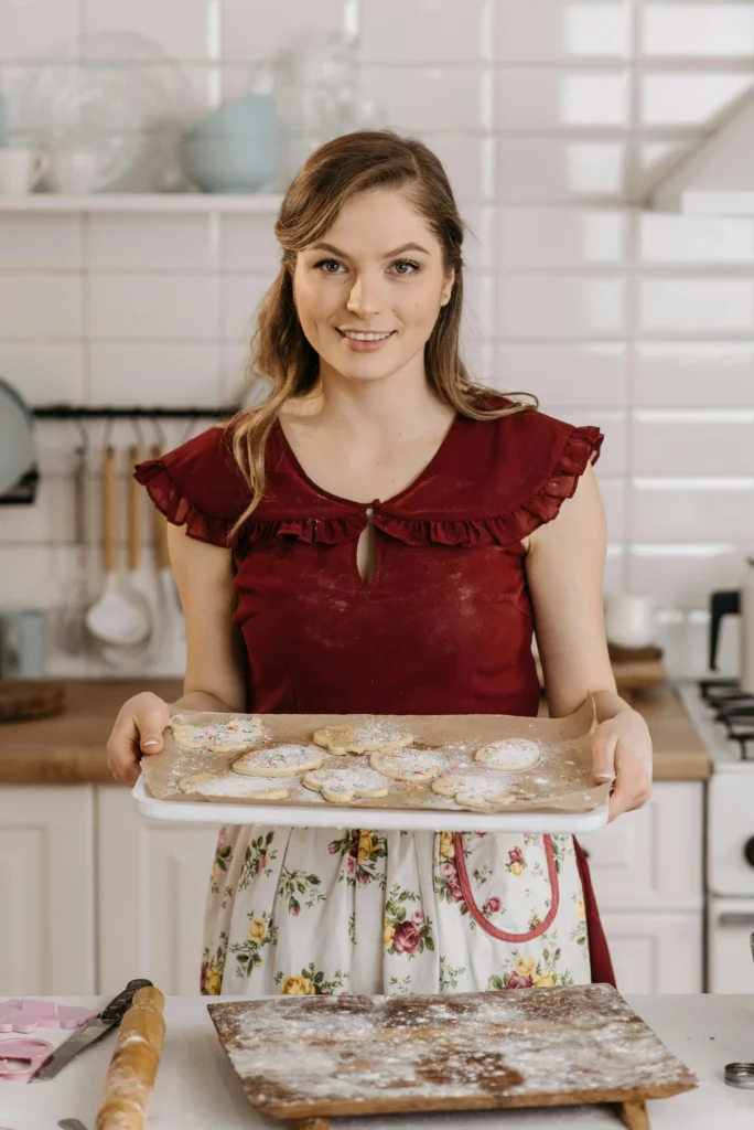 About 1 Riley Sloane, a 35-year-old baker from Austin, Texas, smiling in her light-filled kitchen, surrounded by natural ingredients and aesthetic desserts