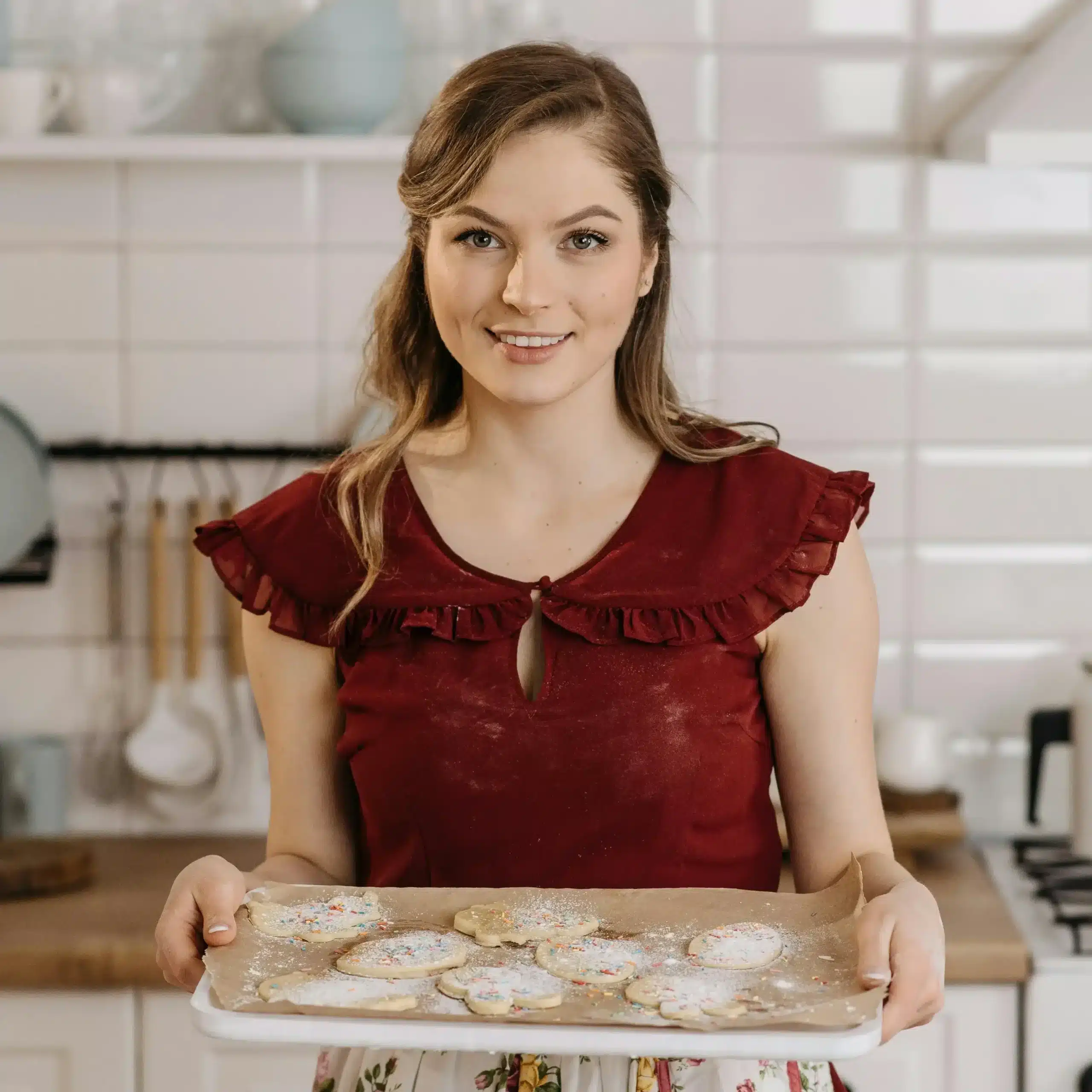 Riley Sloane, a 35-year-old baker from Austin, Texas, smiling in her light-filled kitchen, surrounded by natural ingredients and aesthetic desserts