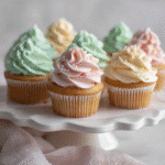 Copycat Magnolia Bakery Cupcakes – Classic Vanilla with Signature Buttercream 3 offlat lay of Copycat Magnolia Bakery Cupcakes with pastel buttercream swirls