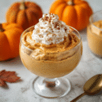 Healthy Pumpkin Mousse 7 Healthy pumpkin mousse in a glass cup topped with whipped cream, cinnamon, and pecans.