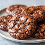 The Best Chocolate Brownie Cookies: Fudgy, Chewy Perfection in Every Bite 9 Fudgy chocolate brownie cookies with shiny cracked tops on a white plate.