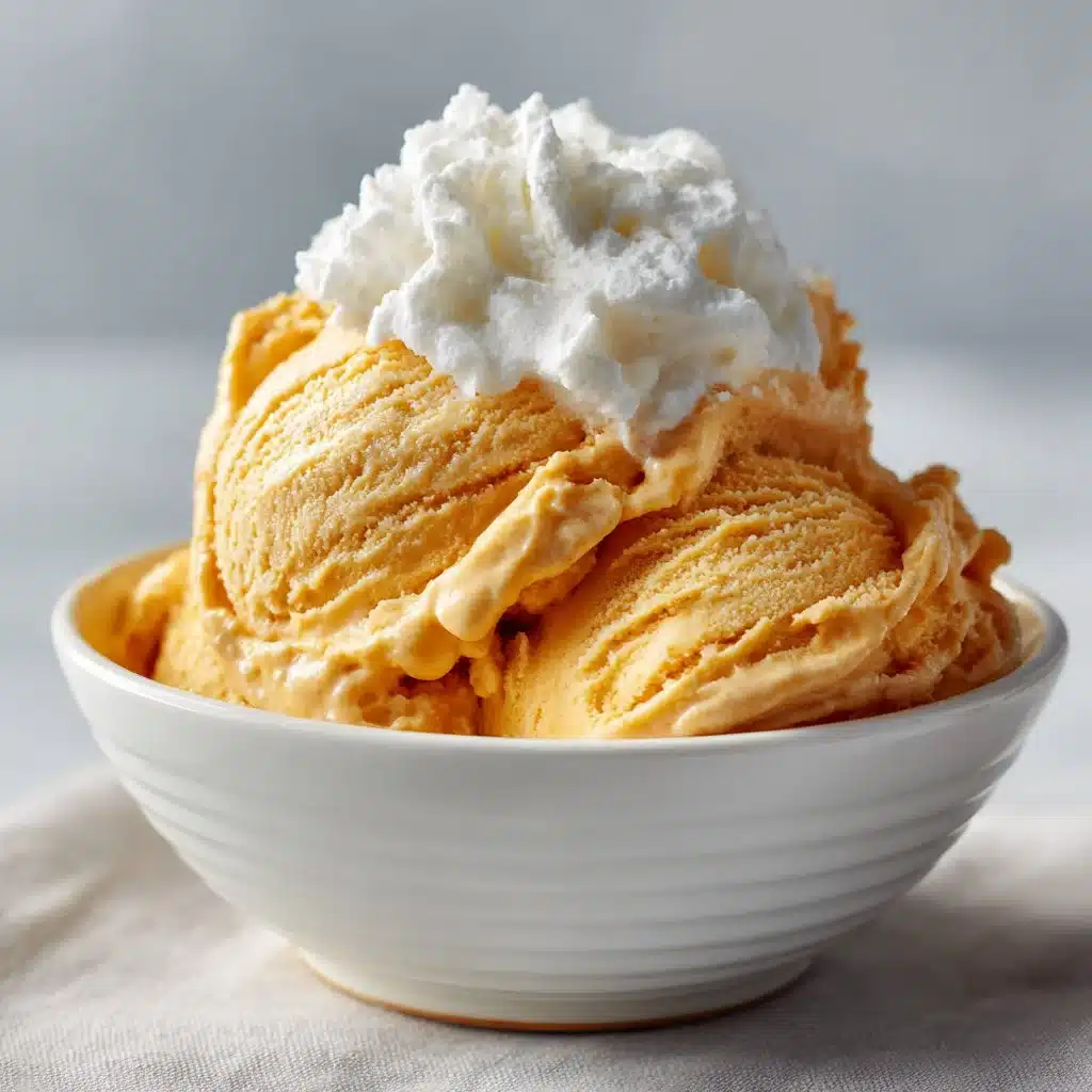 Easy Pumpkin Pie Ice Cream Recipe | Perfect Fall Treat 5 A scoop of pumpkin pie ice cream topped with cinnamon and whipped cream in a bowl.